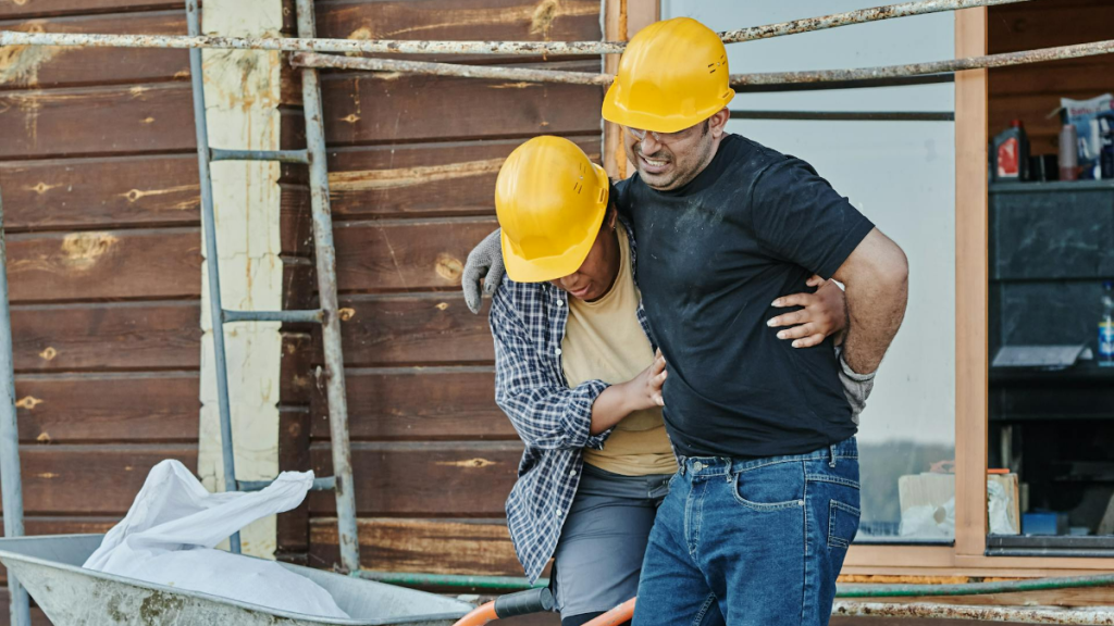 Worker helping fellow colleague after he sustained an injury on the job.