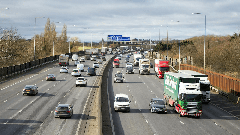 Cars and trucks on busy road.